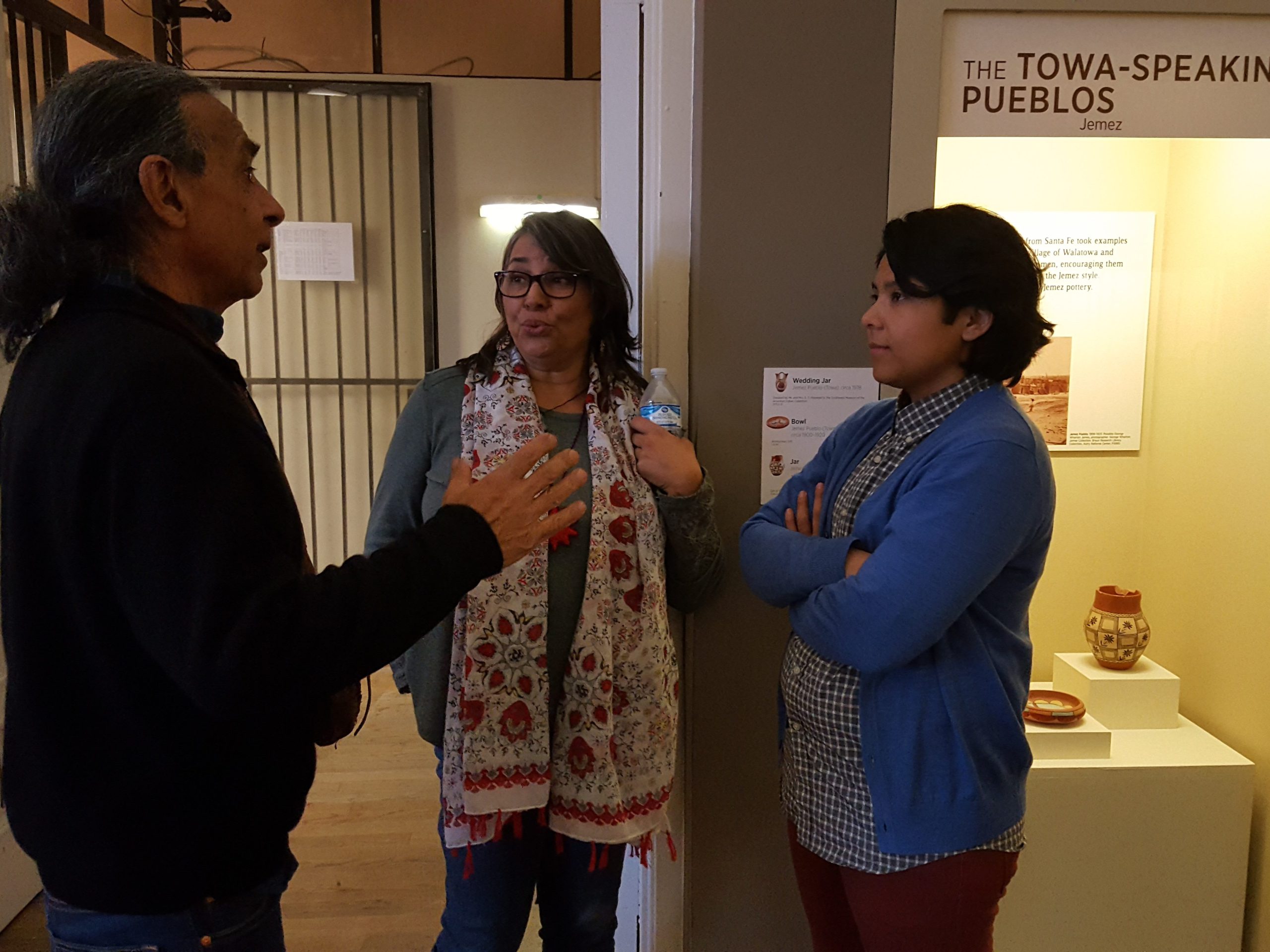 Three people discussing cultural and historic artifacts.