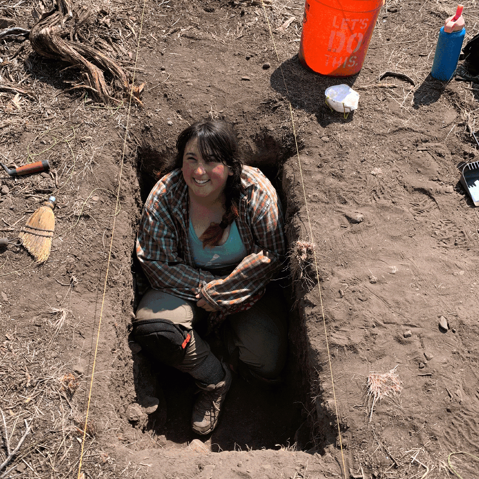 Andrea sitting in a trench at an archaeological site